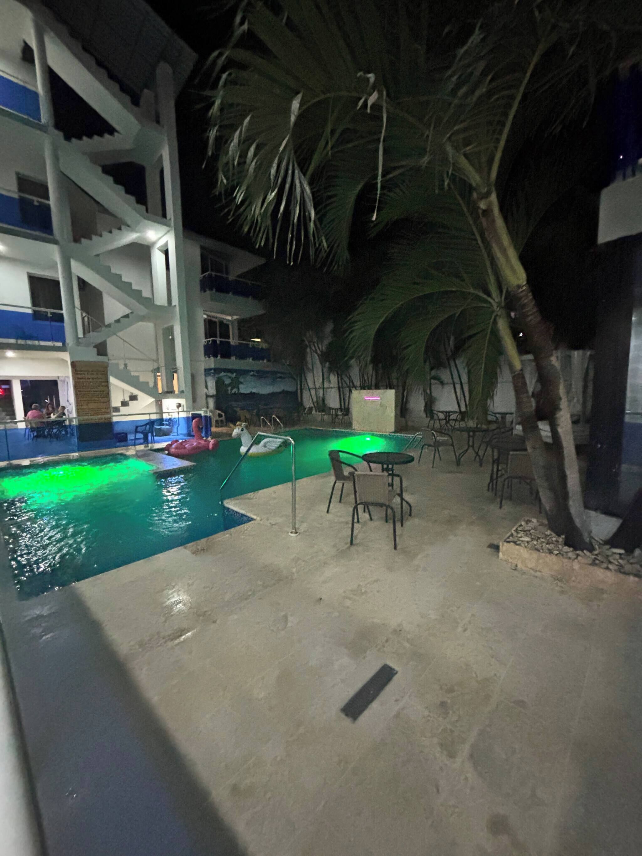 A pool area with a staircase, palm trees, and outdoor seating.