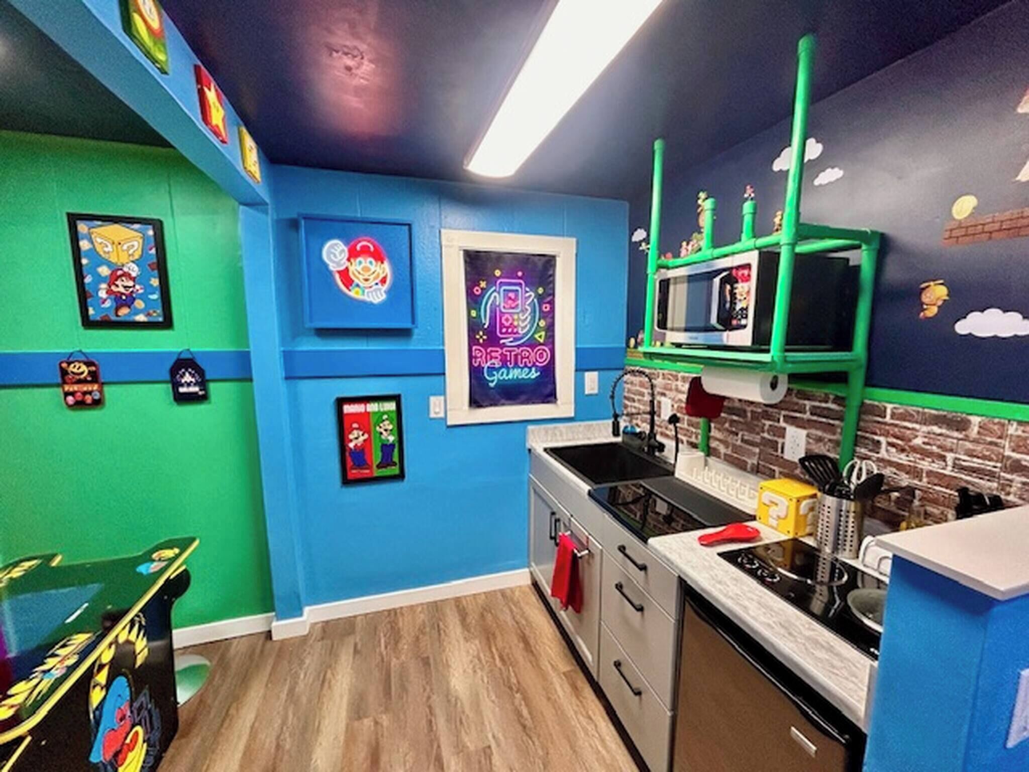 Cozinha com paredes azuis, prateleiras verdes e decoração com tema retrô.