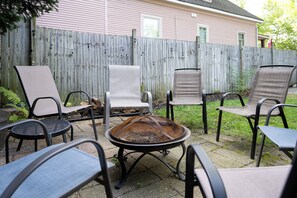 Une terrasse avec des meubles dâextĂ©rieur, un foyer et une clĂŽture en bois.