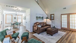 A spacious living area with a staircase, a dining area, and a cozy seating arrangement. - River Access, Starlink, Fire Pit, W/D, Peaceful Discount, Peaceful (Mcgregor)