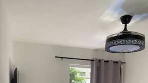 A compact living space with a kitchenette, a sofa, a dining table, and a ceiling fan. - Condo Neuf à Sosua Près de Tout et Équipé, 207 (Sosúa)