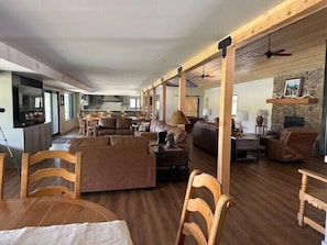 A spacious living area with a fireplace, wooden furniture, and a stone accent wall.