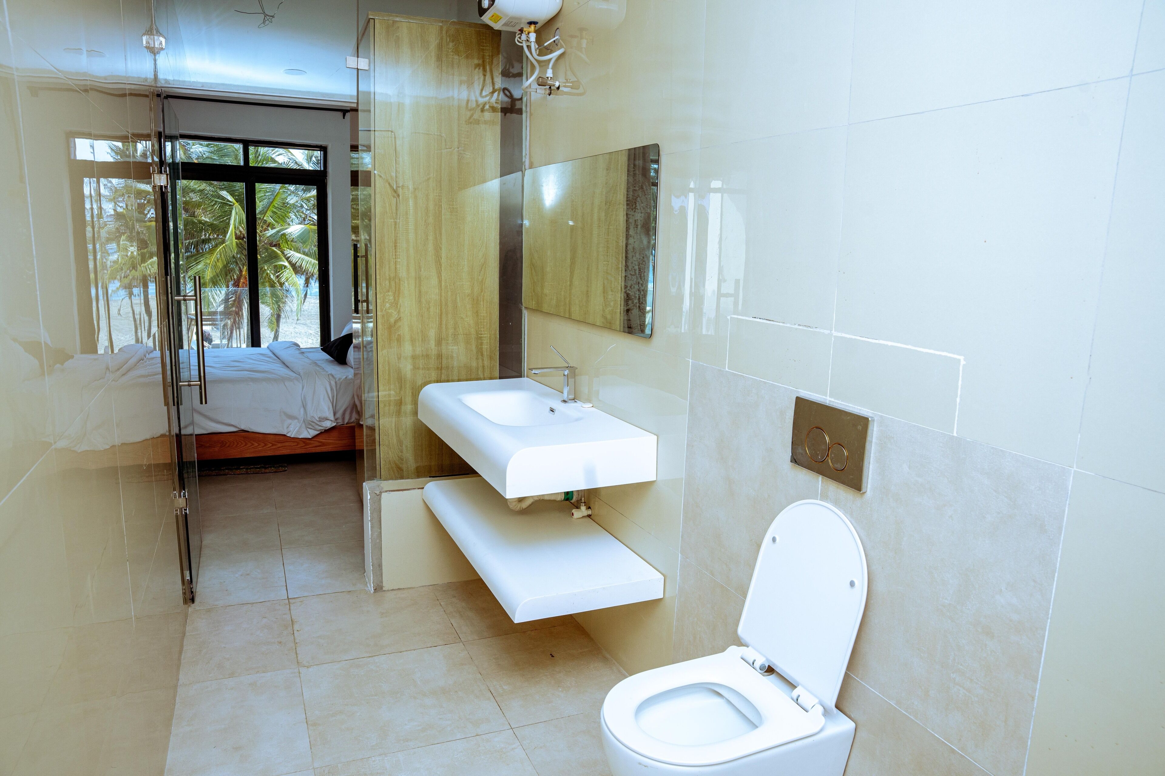 A modern bathroom with a glass shower enclosure, a white sink, and a toilet.