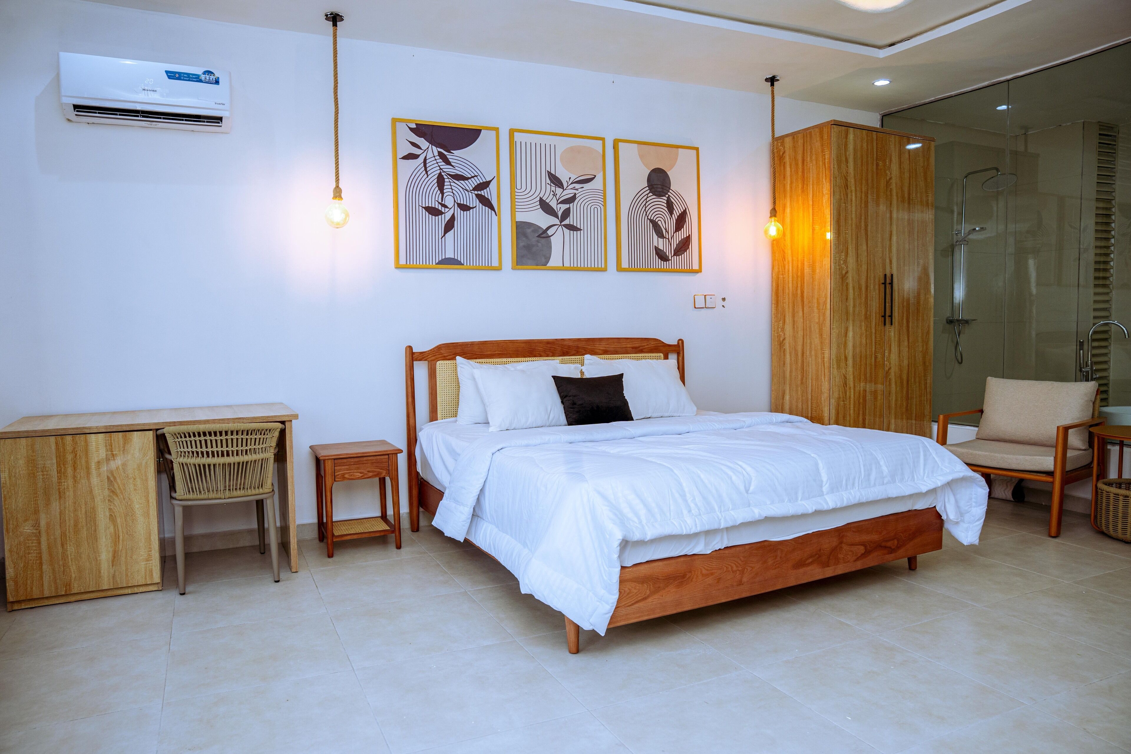 A bedroom with a wooden bed, a desk, a chair, and a shower area.