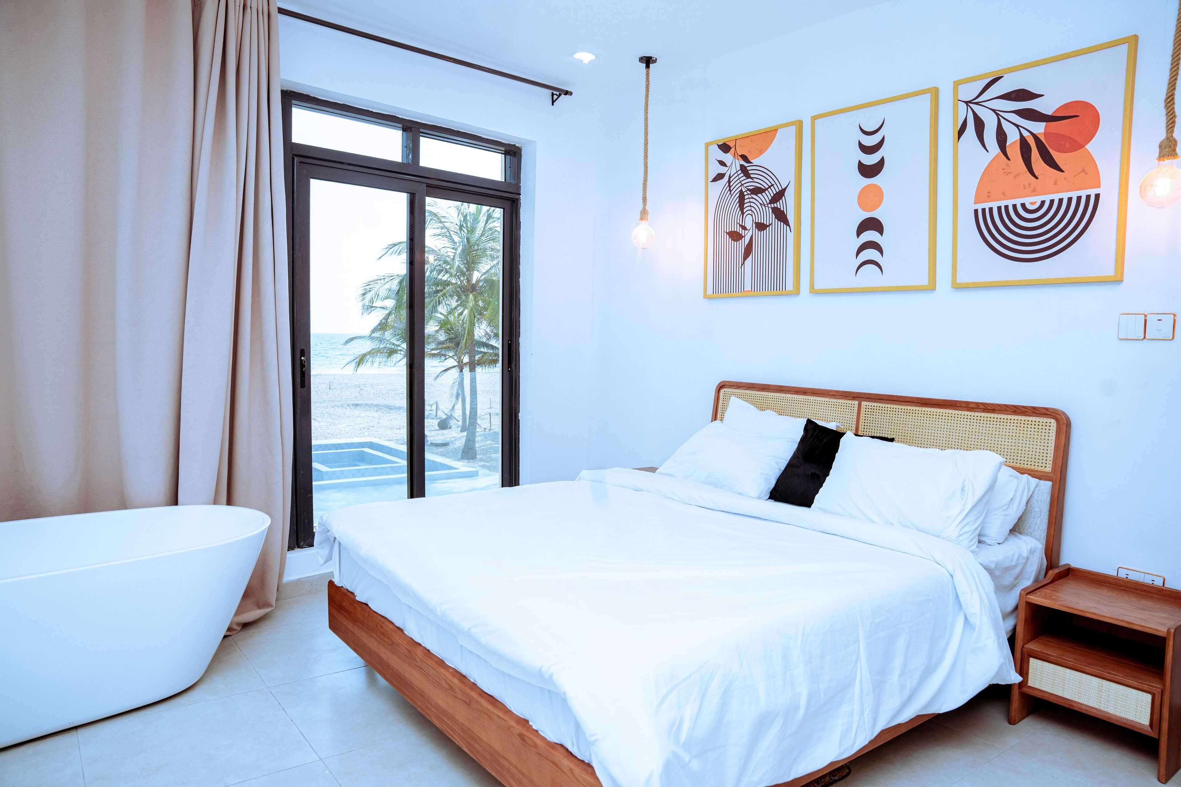 Une chambre moderne avec un grand lit, une baignoire et une vue sur la plage.