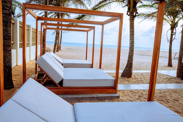 Di pantai, pasir putih, kabana percuma, kerusi lepak pantai