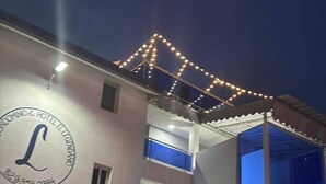 A multi-story building with a prominent 'L' logo, balconies, and a blue door. - Condo Neuf Sosua 3 Minutes de la Plage 208 (Sosúa)