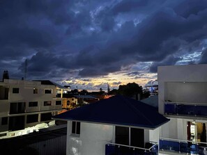Zona residencial con edificios modernos, cielo despejado y atardecer.