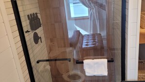 A glass-enclosed shower stall with a toilet and towel rack. - The Cork Cottages Unit 2, Arcade Table, 1K/1Q 2 Bath, New and Modern (Geneva)