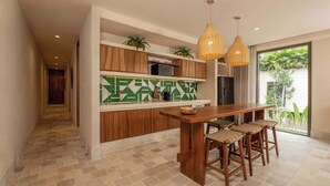 Una cocina moderna con una isla de madera, taburetes de bar e iluminación colgante.