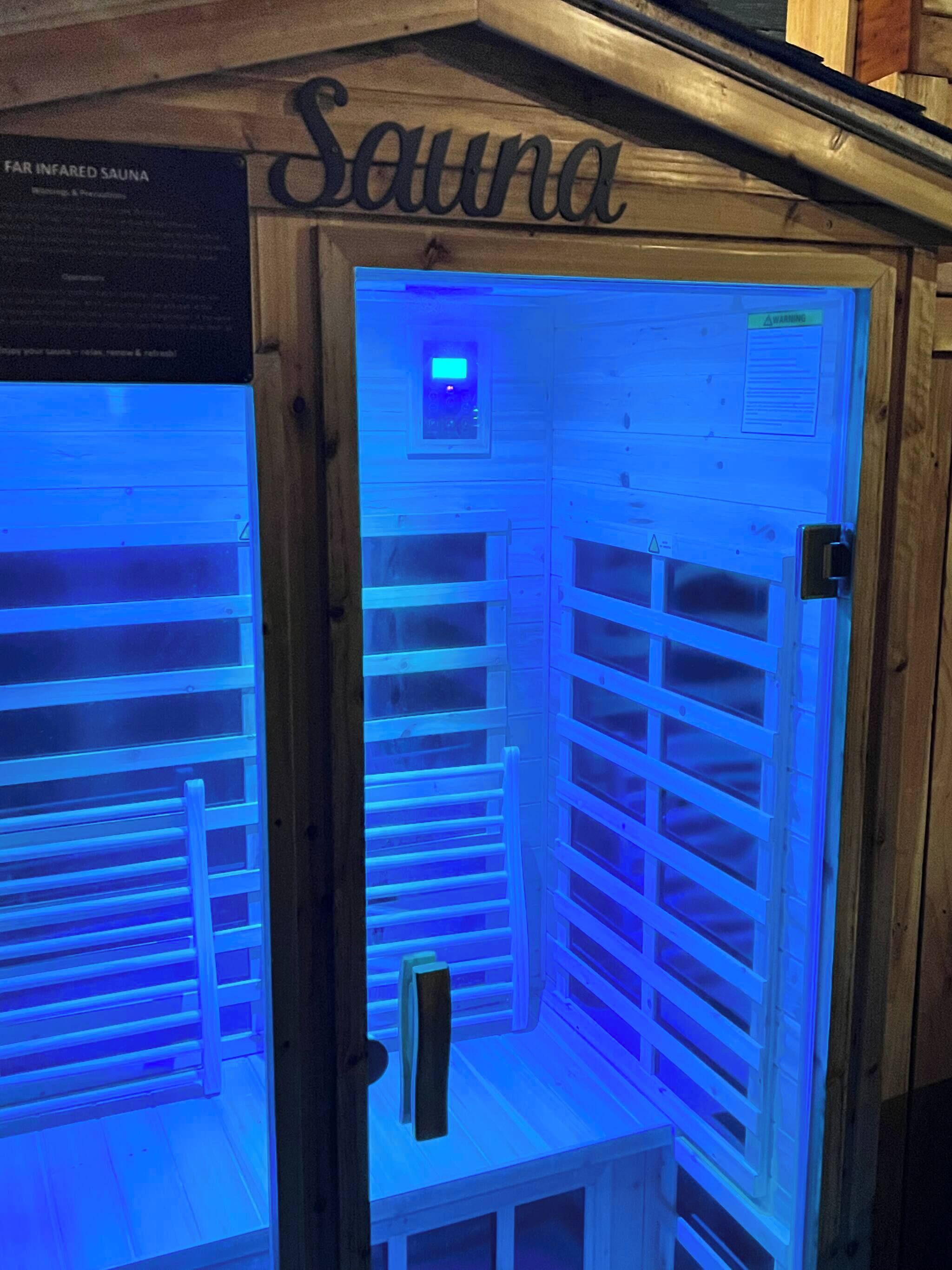 A sauna with a sign reading "Sauna" and a control panel above the entrance.