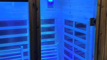 A sauna with a sign reading "Sauna" and a control panel above the entrance.