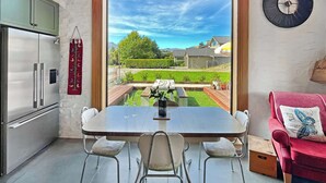 Una cocina moderna con un amplio ventanal, una mesa de comedor con sillas y un sofá rojo.