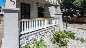 A house with a porch, stone foundation, and a wooden fence. - Deco Studio Retreat With Fireplace, Wifi, Queen Bed (Reno)