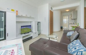 A modern living room with a leather sofa, a flat-screen TV, and a glass coffee table. - Cozy apartment in Brela with WiFi (Brela)