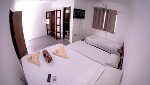 Ένα δωμάτιο ξενοδοχείου με δύο κρεβάτια, μια ντουλάπα, μια τηλεόραση και ένα μπάνιο που φαίνεται μέσα από μια ανοιχτή πόρτα.