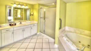 Ein Badezimmer mit einem großen Spiegel, einem Waschbecken, einer Dusche und einer Badewanne.