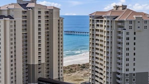 Un hotel de gran altura con varios balcones que dan a una playa y un muelle.