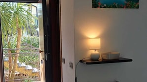 Ein Flur mit einem Sessel, einer Lampe, einem Bild und einer zur Außenseite führenden Tür.
