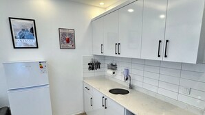 A modern kitchen with white cabinets, a built-in microwave, and a refrigerator. - ESG • 5-Min Walk to Göynük Beach • Mountain View Terrace Studio (Goynuk)
