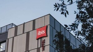 A modern building with a vertical sign for the ibis hotel. - Campanile Rouen Mermoz (Rouen)