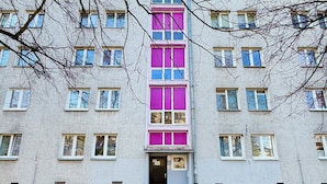 Un immeuble à plusieurs étages doté d’une entrée centrale, de nombreuses fenêtres et d’une façade simple.
