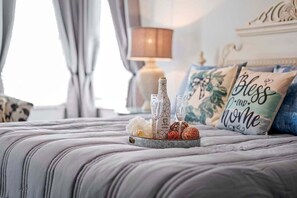 A neatly made bed with a tray of decorative items including a bottle, glasses, and flowers. - A Shore Thing - Direct Gulf Access Southern Facing Villa (Cape Coral)
