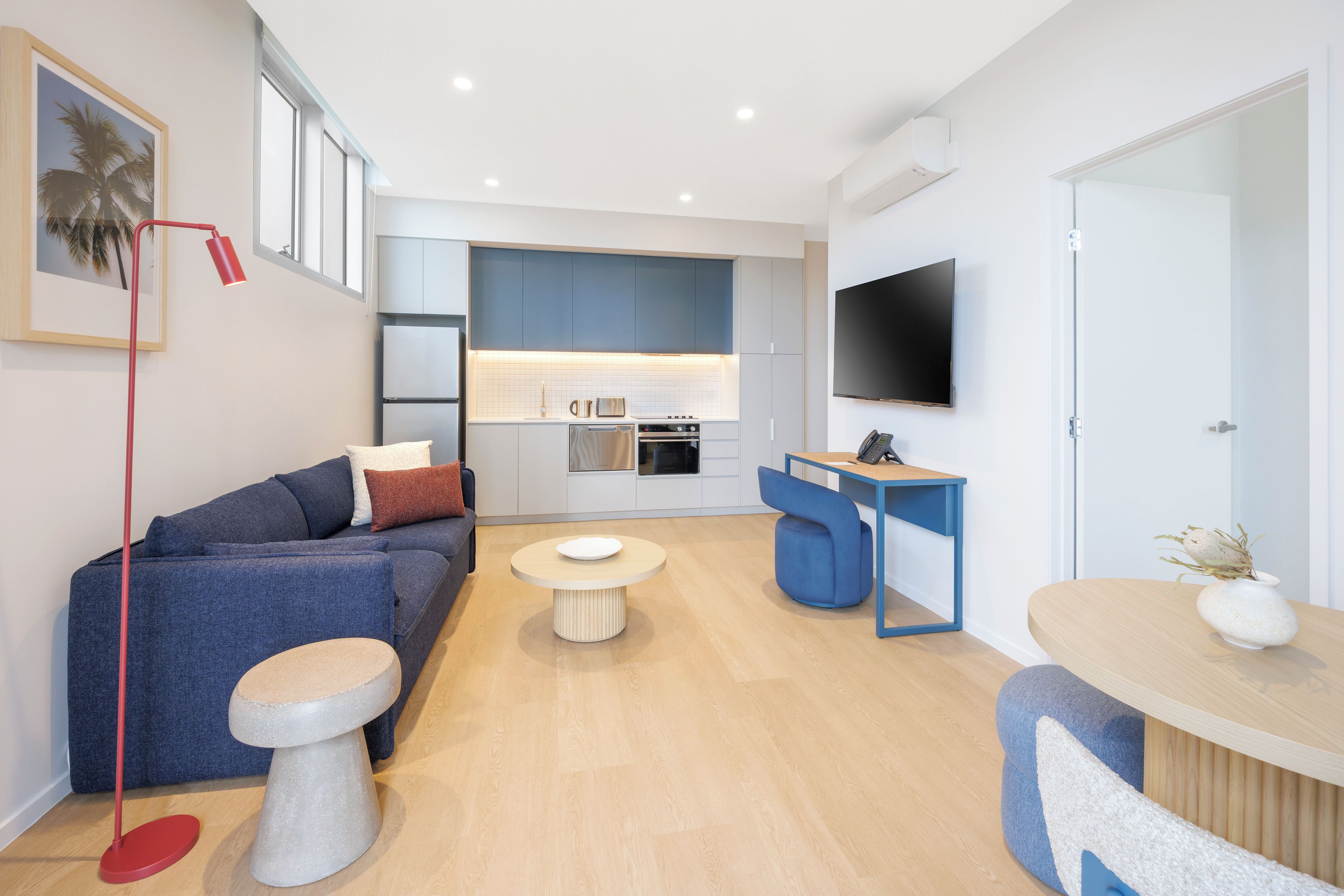 Un salon moderne comprenant un canapé, une table basse et un coin repas avec une table et des chaises.