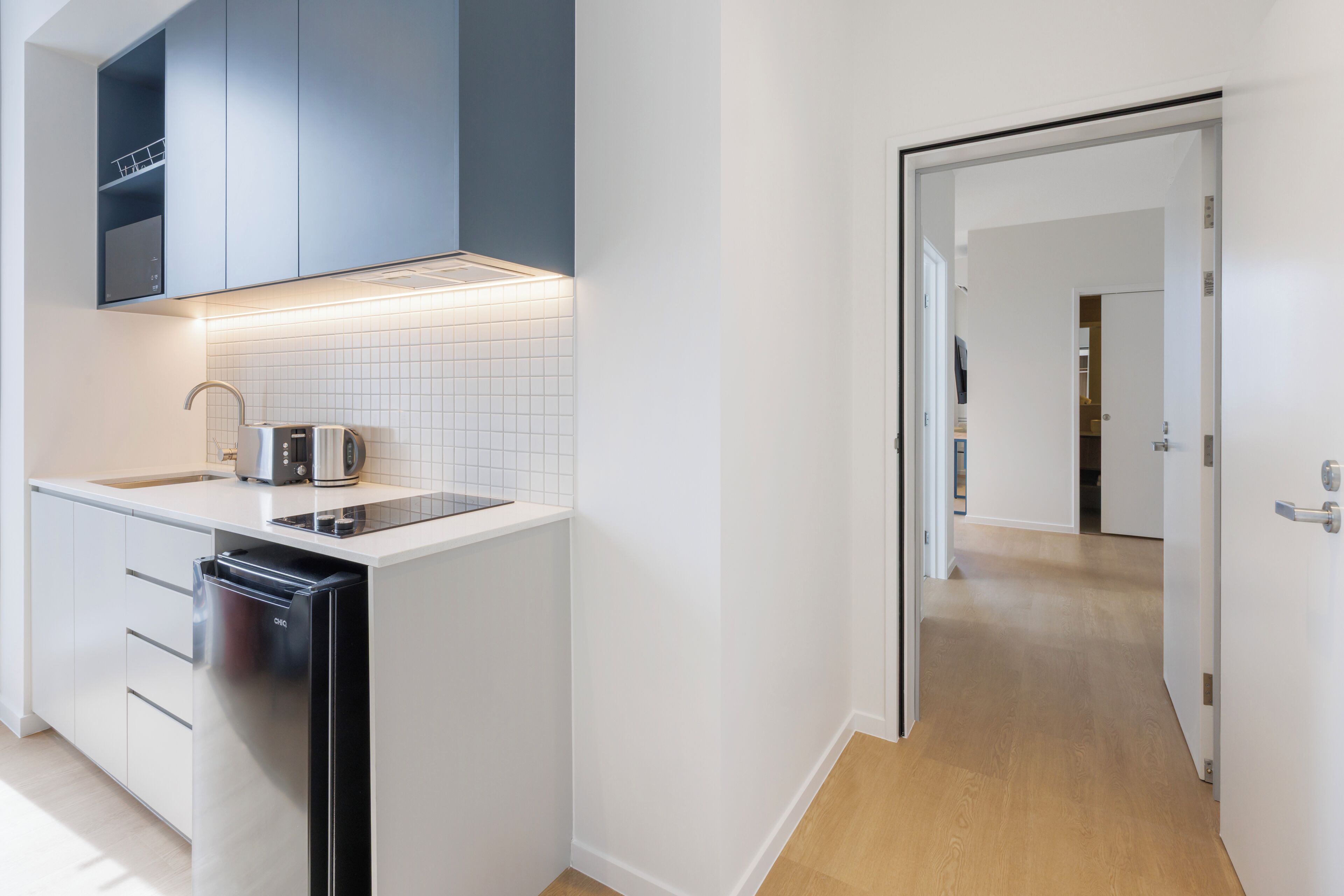 A modern kitchen with a dishwasher, a toaster, and a sink.