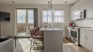 Eine moderne Küche mit einer zentralen Kochinsel, Edelstahlgeräten und einem großen Fenster, das für natürliches Licht sorgt.