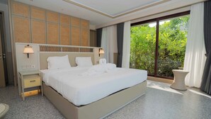 A modern hotel room with a large bed, a nightstand, a lamp, and a view of greenery through the window. - Riahi Villas by Swiss-Belhotel, Nirup Island (Nirup Island)