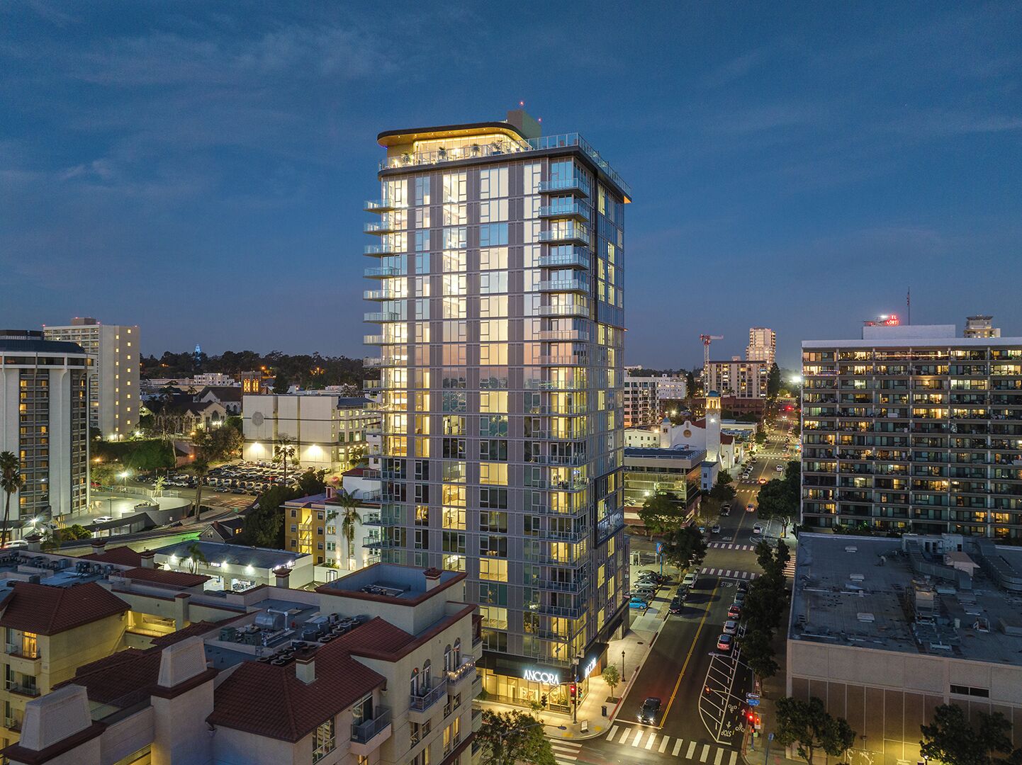 A high-rise hotel with multiple floors, large windows, and a prominent corner location in a cityscape.