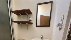 A small bathroom with a toilet, sink, and a mirror on the wall. - Casa de 3-Cuartos de Dormitorios Con Aire AC Santa Ana (Santa Ana)