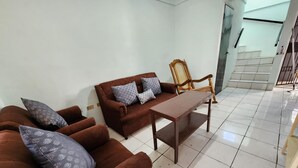 A living room with a brown sofa set, a wooden chair, and a small table. - Casa de 3-Cuartos de Dormitorios Con Aire AC Santa Ana (Santa Ana)