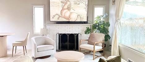 Smart TV, caminetto, libri, impianto stereo