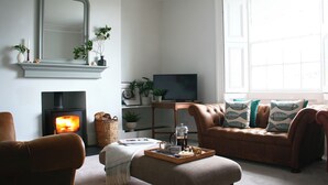Ein gemütliches Wohnzimmer mit Kamin, einer Couch, einem Couchtisch und einem Fernseher.