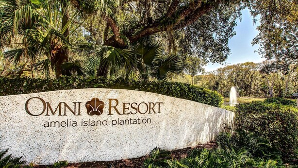 A sign for Omni Resort Amelia Island Plantation with lush greenery and a fountain in the background. - Cozy Villa, Pool View, Near Beach, So Many Amenities! Beach Wood (Fernandina Beach)