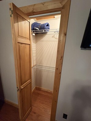 A narrow hallway with a wooden door leading to a closet with a metal shelf. - *NEW* Little Lake Cove: Dual Living Areas & Lake Access (Sevierville)