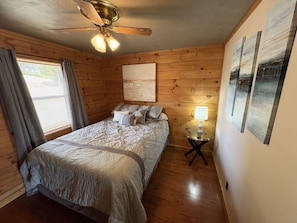 A bedroom with a bed, a ceiling fan, a window with curtains, and wall art. - *NEW* Little Lake Cove: Dual Living Areas & Lake Access (Sevierville)