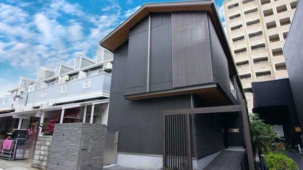 Un edificio moderno con techo plano y un ventanal grande en el segundo piso.