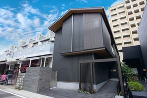 Un bâtiment moderne doté d’un toit plat et d’une grande fenêtre au deuxième étage.