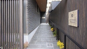Un estrecho sendero que conduce a un edificio con un letrero que dice "Fam Hotel Imaizumi".
