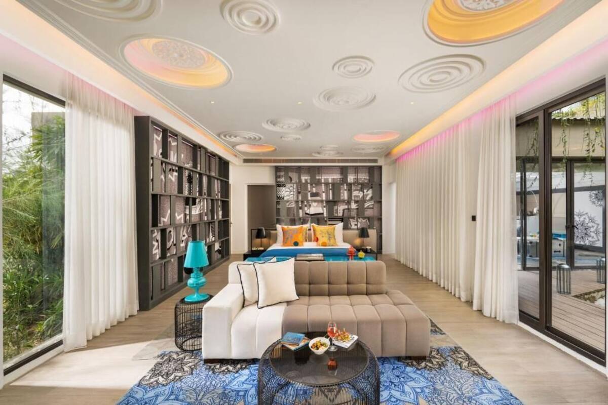 Ein modernes Wohnzimmer mit einer großen Eckcouch, einem Couchtisch und einem Bücherregal.