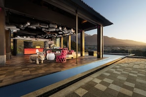 A modern outdoor lounge area with a pool, seating, and a view of mountains. - Norbu The Montanna, Dharamshala - Ihcl Seleqtions (Dharamshala)