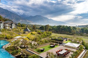 A resort with a swimming pool, outdoor seating, and a view of mountains. - Norbu The Montanna, Dharamshala - Ihcl Seleqtions (Dharamshala)