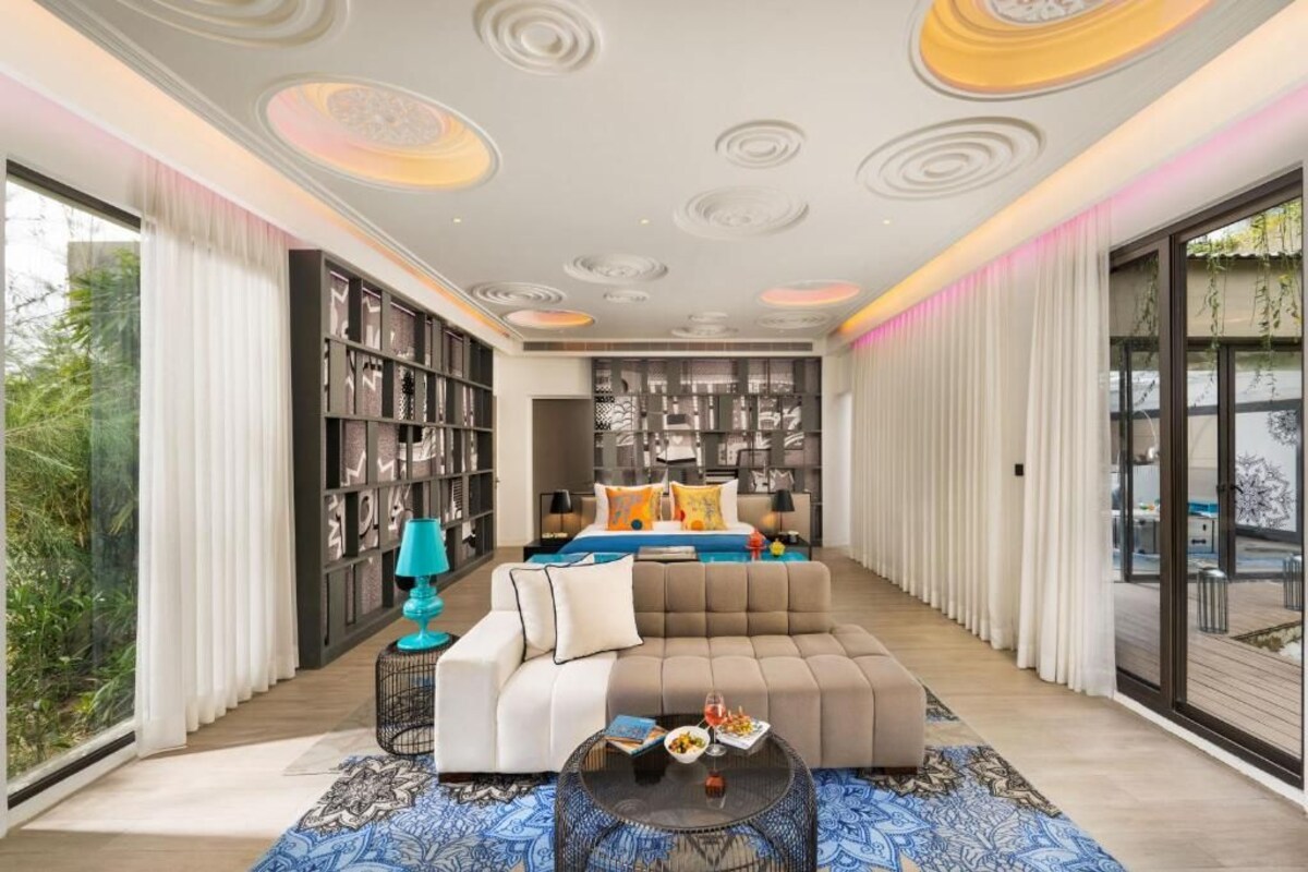 A modern living room with a large sectional sofa, a coffee table, and a bookshelf.