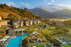 A resort with multiple buildings, a swimming pool, and a view of mountains. - Norbu The Montanna, Dharamshala - Ihcl Seleqtions (Dharamshala)
