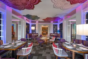 A dining area with tables set for four, chairs, and a central chandelier. - Norbu The Montanna, Dharamshala - Ihcl Seleqtions (Dharamshala)