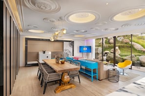 Ein modernes Interieur mit einem Holzesstisch, blauen Möbeln und einem Fernseher an der Wand.