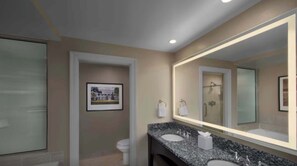A bathroom with a large mirror, a sink, a toilet, and a framed picture on the wall. - Marriott's OceanWatch | Oceanfront 2 BR Villa (Myrtle Beach)